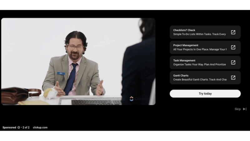 A person with glasses and a beard is talking animatedly, gesturing with one hand. They sit at a table with a laptop, likely discussing project management features. On the right, text highlights these features while hinting at the strategic placement of YouTube Ads to enhance visibility.
