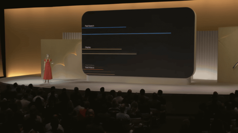 A woman in a red dress stands on stage before a large screen displaying horizontal lines labeled Paid Search, Display, and Paid Videos, presenting Attribution Path Reporting with GA4 insights to a seated audience in a dimly lit auditorium.