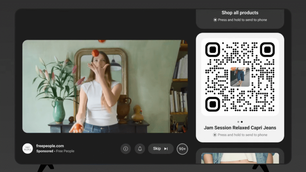 A woman juggles oranges in a living room with a mirror and plants. On the right, a shoppable ad QR code promotes “Jam Session Relaxed Capri Jeans” and a button to shop all products. Website freepeople.com is shown at the bottom.