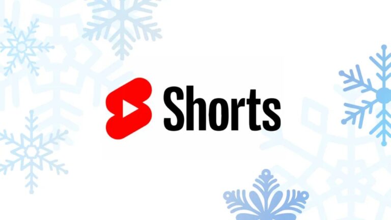 The image shows the YouTube Shorts logo with "Shorts" in black text next to a red play button icon, set against a white background with light blue snowflakes in the corners—highlighting how brands use YouTube Shorts Ads to drive intent.
