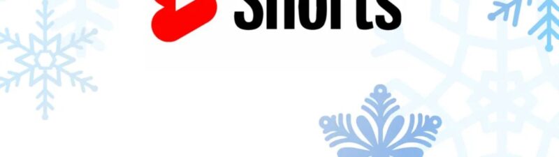 The image shows the YouTube Shorts logo with "Shorts" in black text next to a red play button icon, set against a white background with light blue snowflakes in the corners—highlighting how brands use YouTube Shorts Ads to drive intent.