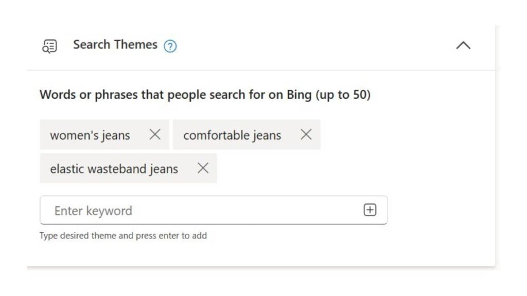 Screenshot of a search themes interface showing three keywords: "women's jeans," "comfortable jeans," and "elastic waistband jeans." A text box lets you add more, with the search theme limit increased to 50 in Microsoft PMAX.