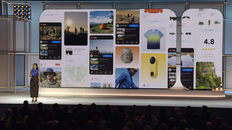 A presenter stands on stage before a large display showing multiple mobile app screens and product listings for outdoor gear and travel content, illustrating digital discovery and AI-powered search results.