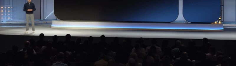 Speaker presenting Google Ads Data Manager API on stage at a conference with large display screen and audience in foreground