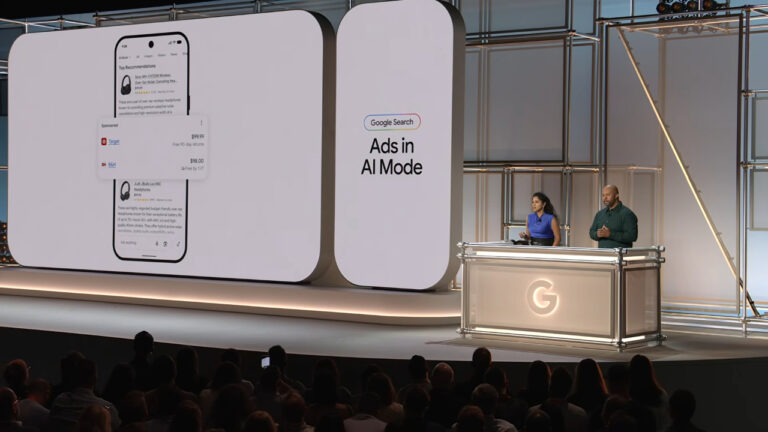 Google Search presentation on stage showing ads in AI Mode feature with shopping products displayed on large screens and two presenters at podium