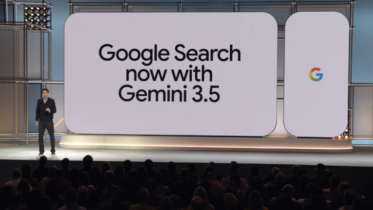 A Google presenter stands on stage in front of a large display screen showing "Google Search now with Gemini 3.5" with the Google logo visible, announcing the AI upgrade to Google Search.