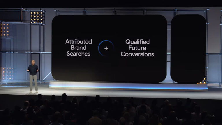 Presenter on stage next to large display showing equation: Attributed Brand Searches plus sign Qualified Future Conversions, illustrating PPC marketing causality concept