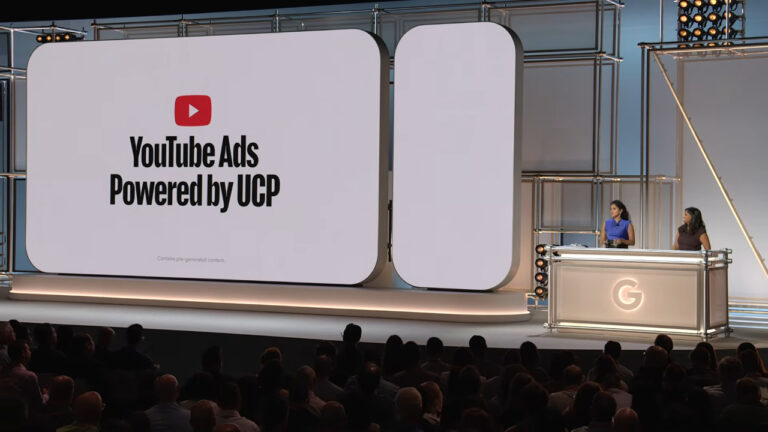 Large presentation screen at a conference displaying YouTube Ads logo with text "Powered by UCP" and note about pre-generated content, with two presenters at a podium below and audience in foreground.