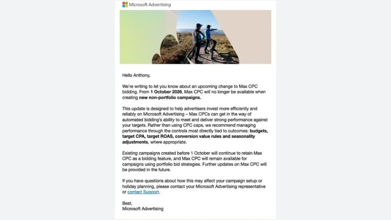 Two cyclists with bikes standing on a mountain trail overlooking a vast landscape